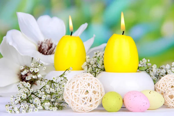 Easter candles with flowers on bright background — Stock Photo, Image