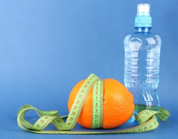 Orange with measuring tape, bottle of water, on color background — Stock Photo, Image