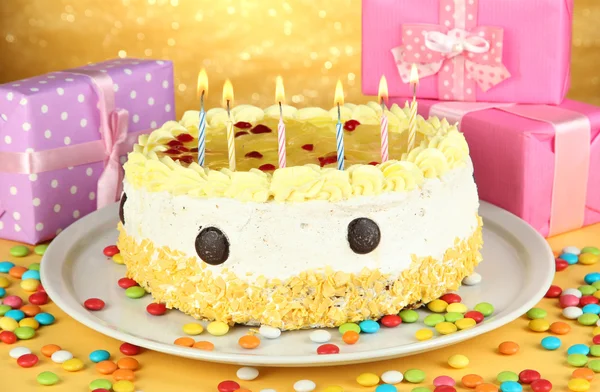 Happy birthday cake and gifts, on yellow background — Stock Photo, Image