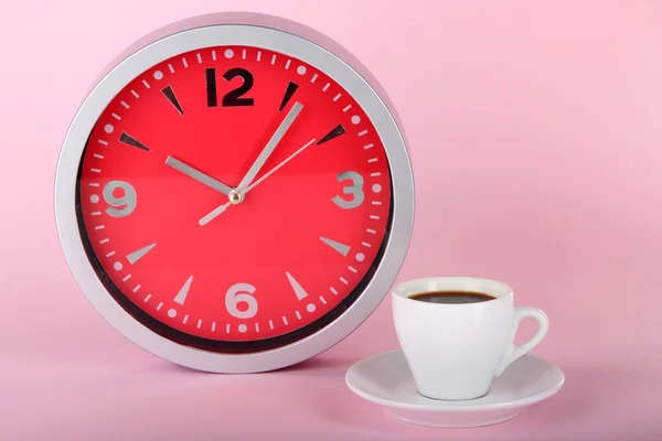 Tazza di caffè e orologio su sfondo rosa — Foto Stock