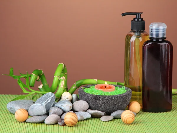 Bodegón con planta de bambú verde y piedras, sobre estera de bambú sobre fondo de color — Foto de Stock