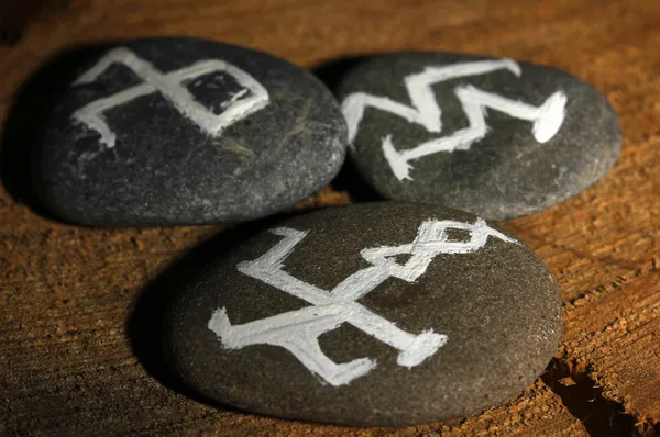 Fortune telling with symbols on stones on wooden background — Stock Photo, Image