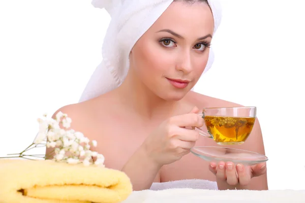 Mulher bonita com toalha na cabeça e xícara de chá de ervas isolado em branco — Fotografia de Stock