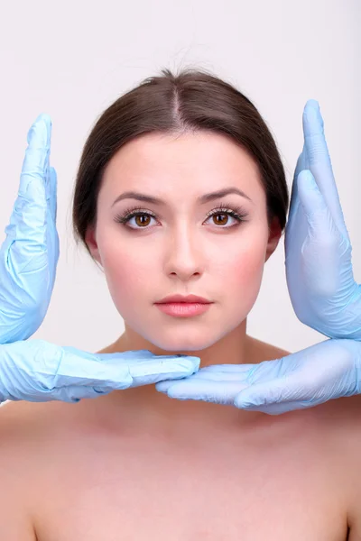 Rubber gloves touching face of young woman close up — Stock Photo, Image