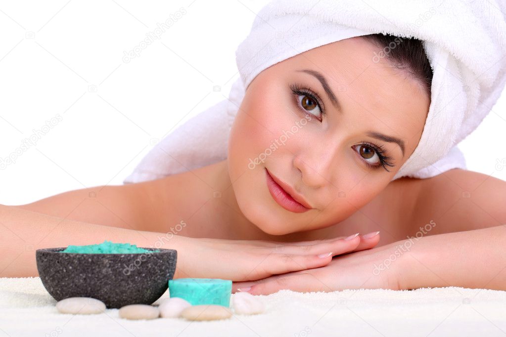 Beautiful young woman with towel on her head and sea salt isolated on white