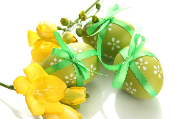 Huevos de Pascua brillantes con lazo y flores, aislados en blanco —  Fotos de Stock