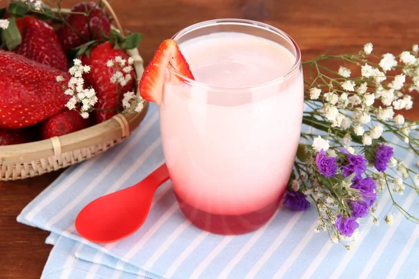 Delicious strawberry yogurt in glass on wooden table close-up — Stock Photo, Image