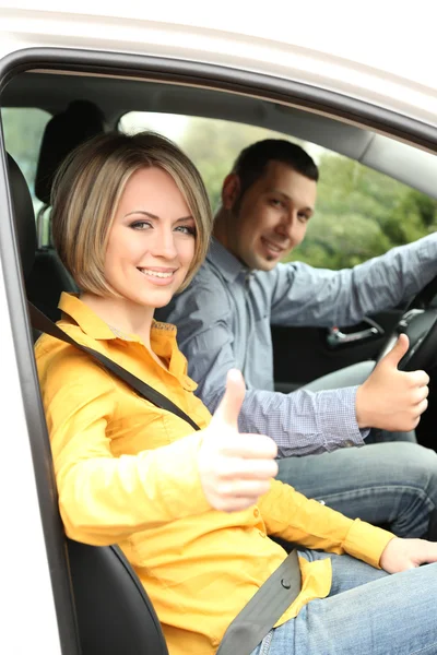 Porträtt av unga vackra paret sitter i bilen — Stockfoto