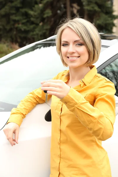 Retrato de mujer hermosa feliz con llaves del coche, de pie cerca del coche —  Fotos de Stock