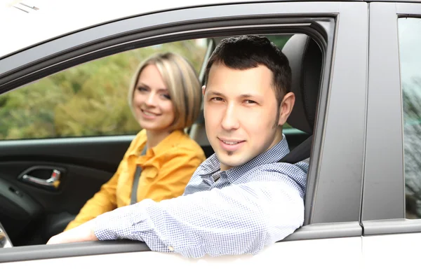 Retrato de jovem casal bonito sentado no carro — Fotografia de Stock