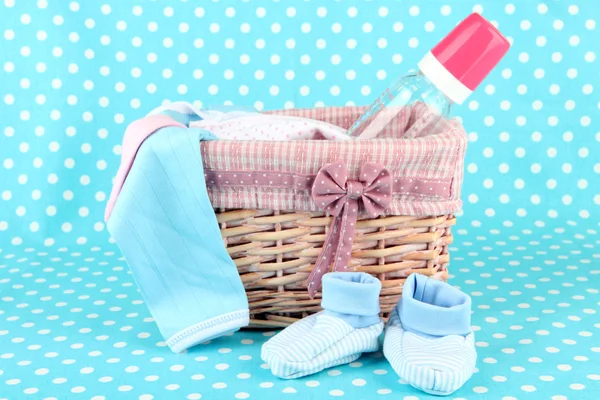 Beautiful basket of baby clothes on a blue background — Stock Photo, Image