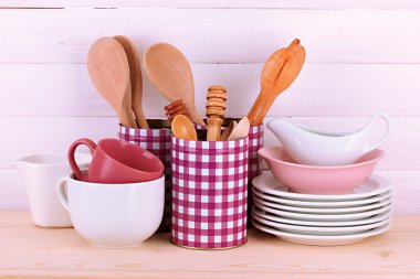 Cups, bowls nd other utensils in metal containers isolated on light background