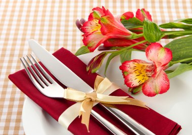Festive dining table setting with flowers on checkered background clipart