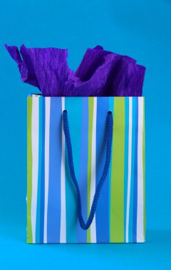 mavi arka plan üzerinde çizgili alışveriş çantası