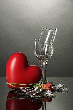 kırık bardağı ve gri arka plan üzerinde kalp