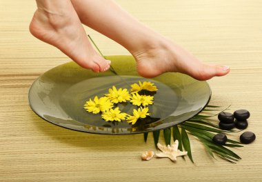 kadın ayakları suda, bambu hasır spa kase