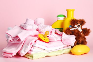 pembe bir arka plan üzerinde bebek elbise yığını