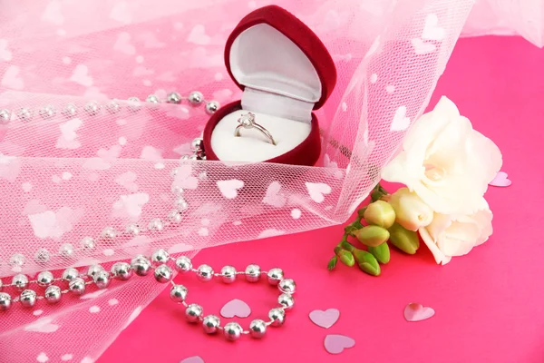 Όμορφο κουτί με το γαμήλιο δαχτυλίδι και λουλούδι σε ροζ φόντο — Φωτογραφία Αρχείου