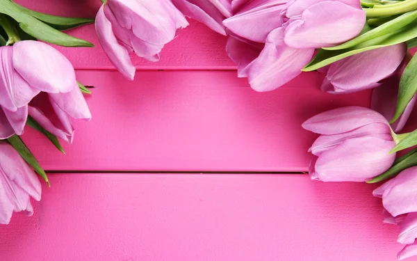 Hermoso ramo de tulipanes morados sobre fondo de madera rosa —  Fotos de Stock