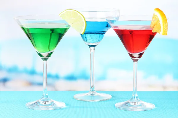 Glasses of cocktails on table near pool — Stock Photo, Image