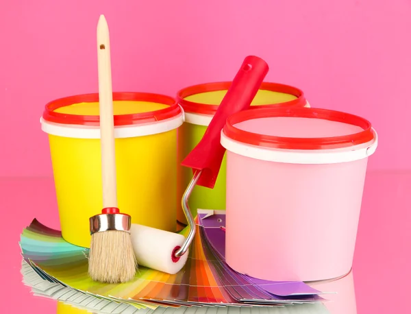 Instellen voor schilderij: schilderen potten, penselen, verf-roller, palet van kleuren op roze achtergrond — Stockfoto