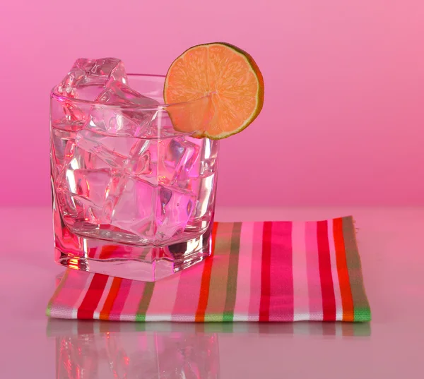 Ijs in een glas op een achtergrond in kleur — Stockfoto