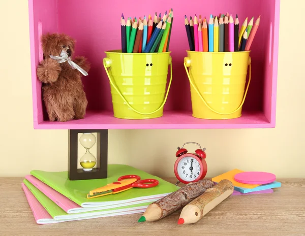 Colorful pencils in pails on shelf on beige background — Stock Photo, Image