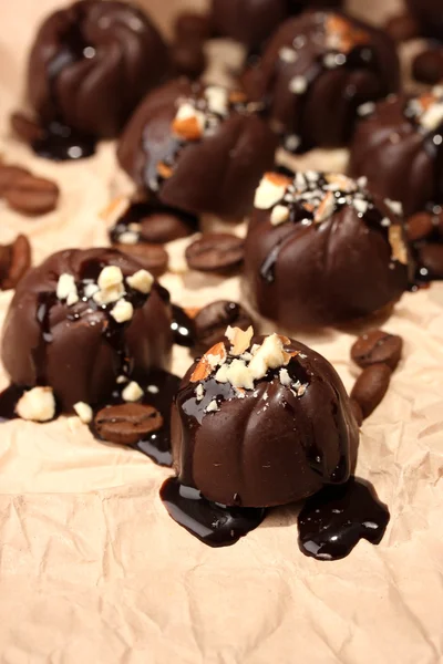 チョコレート菓子、コーヒー豆、ベージュの用紙の背景 — ストック写真