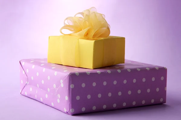 Bright gifts with bows on purple background — Stock Photo, Image