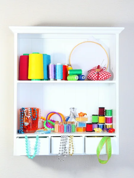 Beautiful white shelves with thread and material for handicrafts — Stock Photo, Image