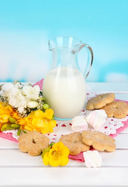 Beautiful composition of milk and cookies on wooden picnic table on natural background — Stock Photo, Image