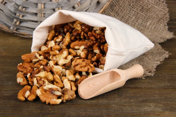 Nuts in sack on wooden background — Stock Photo, Image