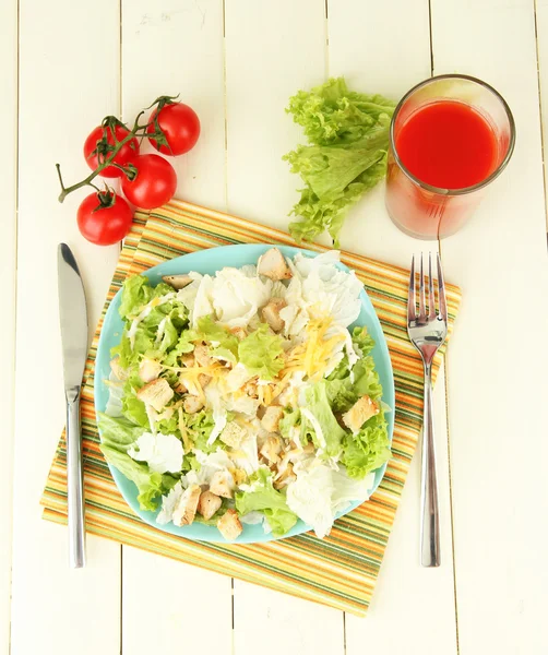 Ensalada César sobre plato azul, sobre fondo de madera color — Foto de Stock