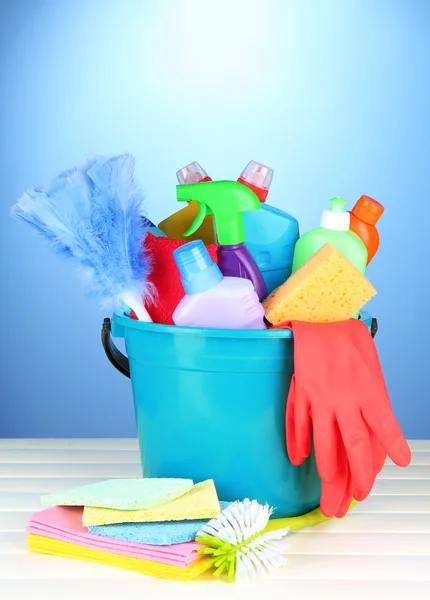 Produtos de limpeza em balde sobre fundo de cor — Fotografia de Stock