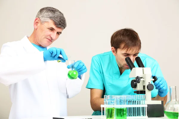 Médico y ensayador durante la investigación sobre el fondo de la habitación — Foto de Stock