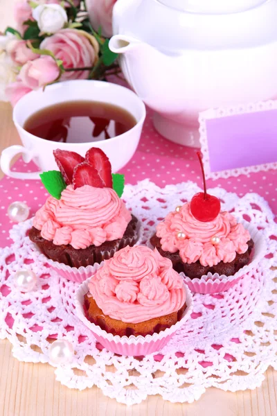 Beautiful strawberry cupcakes and flavored tea on dining table close-up — Stock Photo, Image