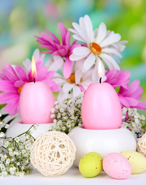 Osterkerzen mit Blumen auf hellem Hintergrund — Stockfoto