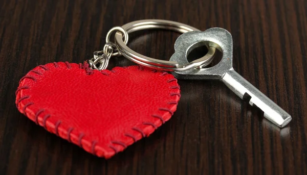 Key with leather trinket on wooden background — Stock Photo, Image