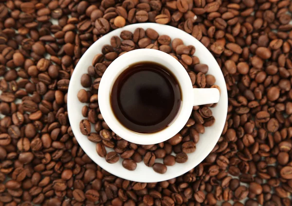 Cup of coffee on coffee beans background — Stock Photo, Image