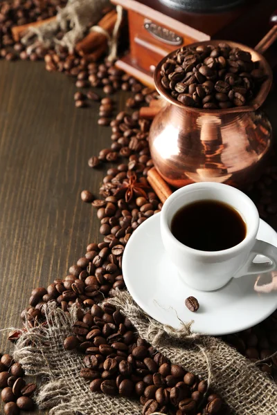 Cup of coffee, pot and grinder on wooden background — Stock Photo, Image