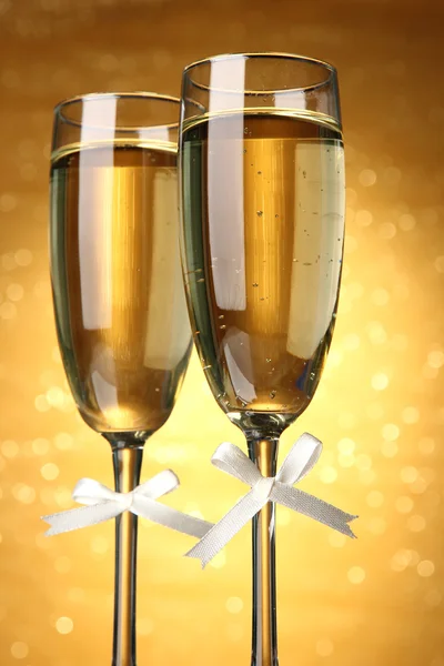 Two glasses of champagne on bright background with lights — Stock Photo, Image