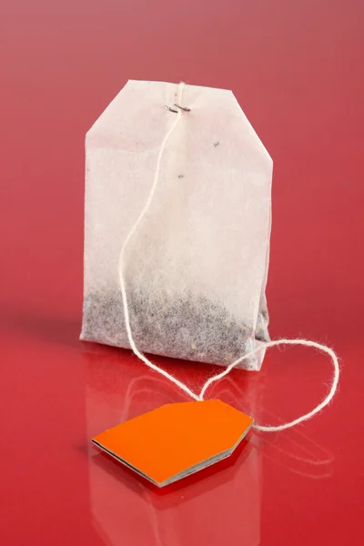 Tea bag, piros háttér — Stock Fotó