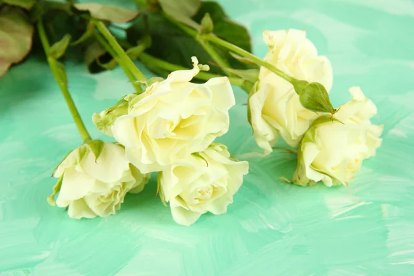 Schöne weiße Rosen in Nahaufnahme, auf farbigem Hintergrund — Stockfoto