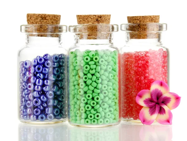 Små flaskor med färgglada pärlor isolerade på vit — Stockfoto