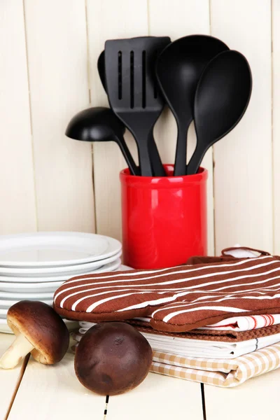 Kitchen settings: utensil, potholders, towels and else on wooden table — Stock Photo, Image