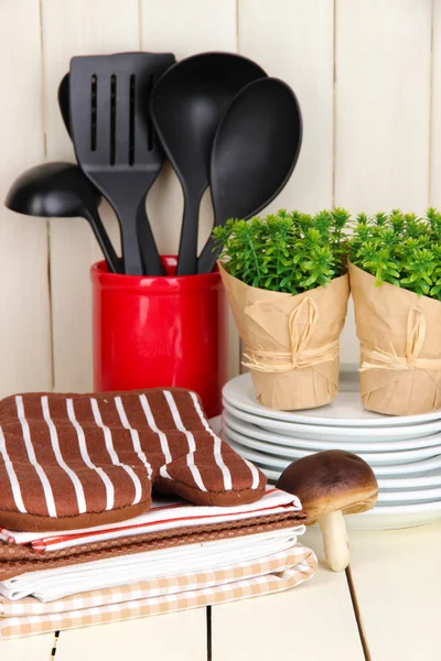 Configurações da cozinha: utensílio, pegadores de panela, toalhas e muito mais na mesa de madeira — Fotografia de Stock