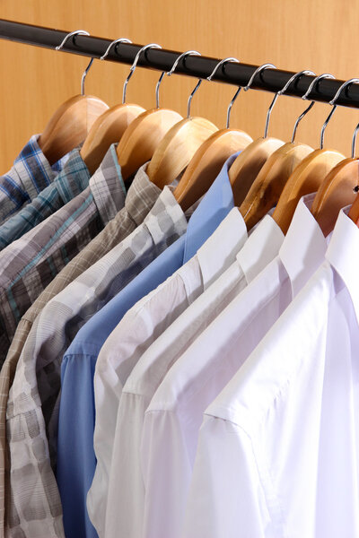 Men's shirts on hangers in wardrobe