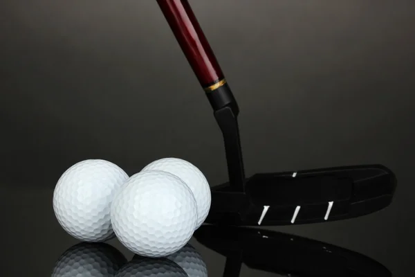Pelota de golf y conductor sobre fondo gris — Foto de Stock