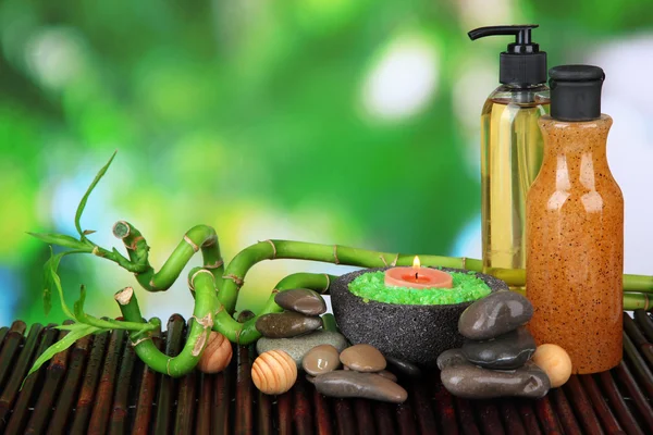 Still life with green bamboo plant and stones, on bamboo mat, on bright background — Stock Photo, Image