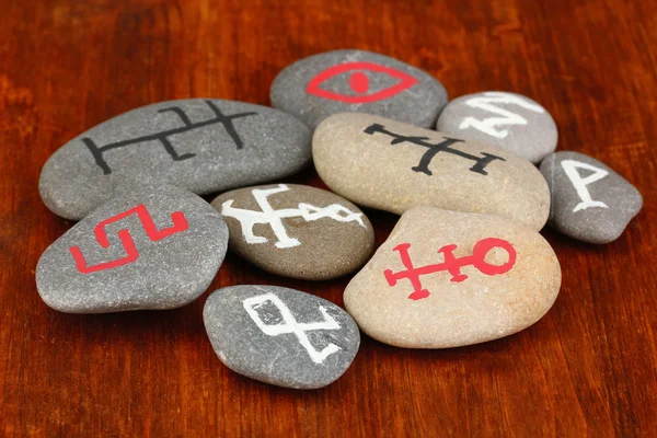 Fortune telling with symbols on stones on wooden background — Stock Photo, Image